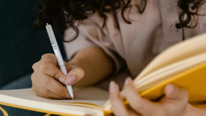 person writing in notebook