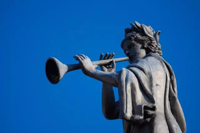 A statue blowing a trumpet